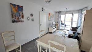 a living room with a white table and chairs at Lodge coeur nature T3 in Argelès-sur-Mer