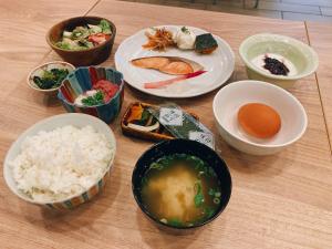 a table with plates of food and bowls of rice at Hotel Il Fiore Kasai in Tokyo