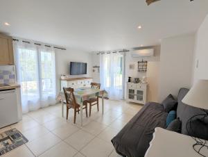 a kitchen and living room with a table and a couch at Gîte La Clef du Sud - Cosy 4 pers, parking gratuit, EuroVelo 8 in Salernes +10 photos