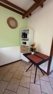 a small kitchen with a table and a refrigerator at Vai Hea Lodge in Taputapuapea +12 photos