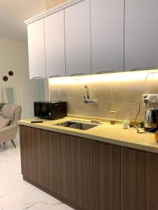 a kitchen with a sink and a microwave at Carmel Residence - كارمل ريزيدنس in Baghdād