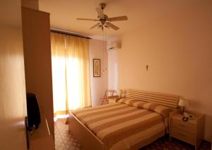 a bedroom with a bed and a ceiling fan at Albergo Tre Stelle in Marina di Grosseto