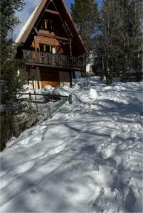 a snow covered path in front of a log cabin at Chalet Le refuge in Allos +23 photos