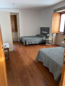 a bedroom with two beds and a wooden floor at Casa de José in Cabeceiras de Basto +33 photos