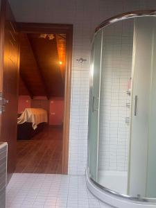 a bathroom with a glass shower and a bedroom at Chaido's attic in Larisa