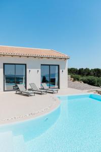 a villa with a swimming pool and a house at Tempestini Exclusive Villas in Nikiana