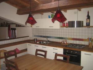 a kitchen with a table and a sink and a stove at Casa Vacanza La Valle in Urbino