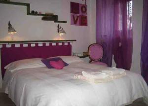 a bedroom with a large bed with purple curtains at Casa Vacanza La Valle in Urbino +10 photos