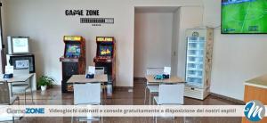 a room with two video games and tables and two machines at Hotel Residence Mara in Lido di Jesolo