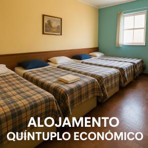 two beds in a hotel room with the words albuquerque univocado at Alojamento Pousada Economica Canoas in Canoas