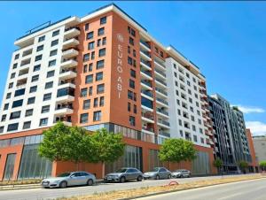a building with cars parked in front of it at Prishtina Apartment in Prishtinë