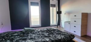 a bedroom with a bed and a dresser and two windows at Prishtina Apartment in Prishtinë +4 photos