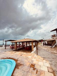 a resort with a swimming pool and a pavilion at Pousada beira mar e sol in Tibau