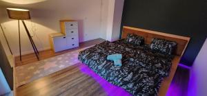 a bedroom with a bed with purple lights on it at Prishtina Apartment in Prishtinë