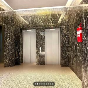 a bathroom with four elevators with a remote control on the floor at Prishtina Apartment in Prishtinë