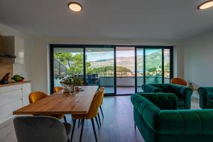 a living room with a wooden table and green chairs at Korcula Hill in Korčula