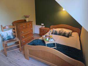 a bedroom with a bed and a chair with a tray on it at W Olchach - lokal Klon in Wiktorowo