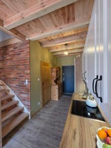 a kitchen with wooden ceilings and a brick wall at W Olchach - lokal Klon in Wiktorowo