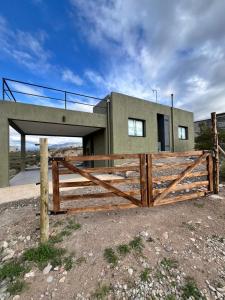 a house with a wooden fence in front of it at Dos Cumbres in Ciudad Lujan de Cuyo