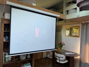 a large screen in a room with a table and chairs at 'T Dijkhuisje - Driehuizen in Driehuizen