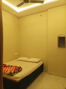a bedroom with a bed with a ceiling fan at आदिनाथ गेस्ट हाउस in Ujjain