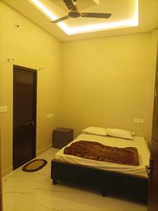 a bedroom with a bed and a ceiling fan at आदिनाथ गेस्ट हाउस in Ujjain