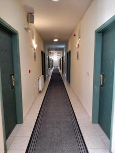 an empty hallway in a hospital with green doors at Hotel Slodes in Belgrade