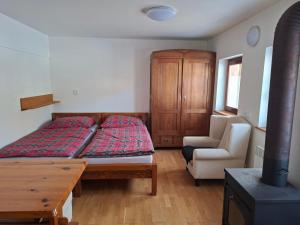 a bedroom with a bed and a desk and a chair at Chalupa Rumovka in Ostružná