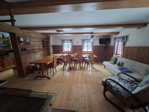 a living room with a table and chairs and a couch at Chalupa Rumovka in Ostružná