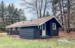 a small blue house in a field with trees at 2 Bedroom Nice Home In Hundested in Hundested