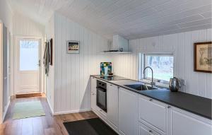 a white kitchen with a sink and a stove at 2 Bedroom Nice Home In Hundested in Hundested +6 photos