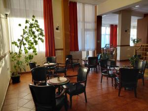 a waiting room with tables and chairs and windows at Hotel Slodes in Belgrade