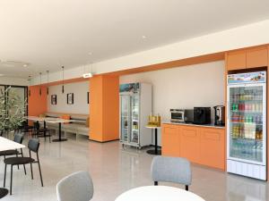 a cafeteria with orange cabinets and tables and chairs at Fortune D Hotel Loei in Loei +7 photos