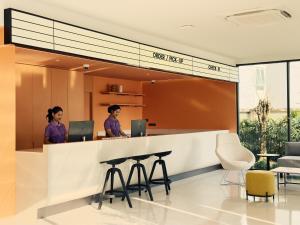 two women standing at a reception desk in a lobby at Fortune D Hotel Loei in Loei