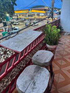 two benches and tables on a balcony with a view of a city at Pousada Torre dos Mouros in Pirenópolis +8 photos