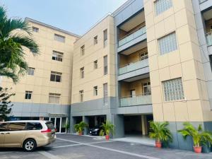a large building with a car parked in a parking lot at Eterniti by Amber in Lagos