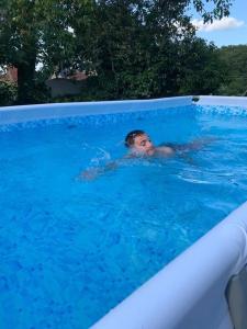 a man is swimming in a swimming pool at Gîte ABMA in Clugnat