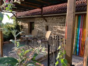a patio with chairs and a table and a building at Gîte ABMA in Clugnat