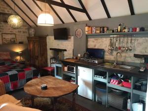 a kitchen with a sink and a table in a room at Gîte ABMA in Clugnat