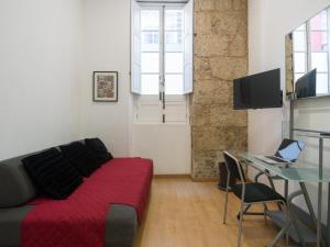 a living room with a couch and a table with a laptop at Celia House in Las Palmas de Gran Canaria