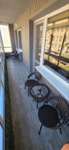 a patio with three chairs and tables on a balcony at Еви 1 in Gabrovo