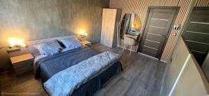 a bedroom with a bed with blue sheets and a television at Еви 1 in Gabrovo