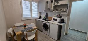 a kitchen with a washing machine and a table with chairs at Еви 1 in Gabrovo
