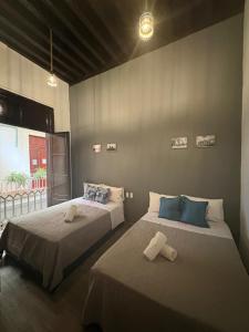 a bedroom with two beds and a large window at Hotel Zamora Downtown CDMX in Mexico City