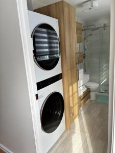 a bathroom with a washer and dryer in a room at Floral'Anse in LʼAnse-Saint-Jean +46 photos
