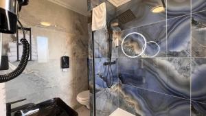 a bathroom with a shower with a glass door at Contact Hôtel Le Continental in Vierzon +32 photos