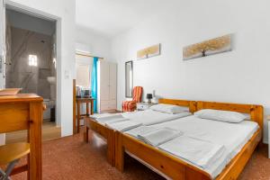 a bedroom with a large wooden bed with white sheets at Κοχειλα Ματουλα Ενοικιαζόμενα Δωμάτια in Spetses