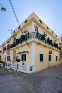 a yellow building with a balcony on top of it at Κοχειλα Ματουλα Ενοικιαζόμενα Δωμάτια in Spetses +11 photos