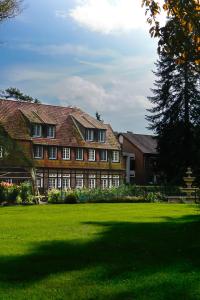 a large building with a green lawn in front of it at Heidehotel Waldhütte in Telgte