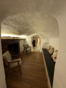 a room with a fireplace and a bed and a couch at Casa Cueva Conde in Guadix